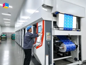 Worker operating high speed gravure printing machine for custom printed packaging bags